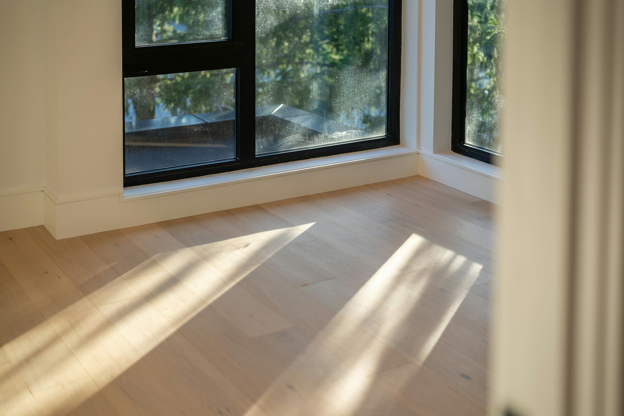 Pièce lumineuse aux murs fraîchement repeints, soleil rasant sur le parquet
