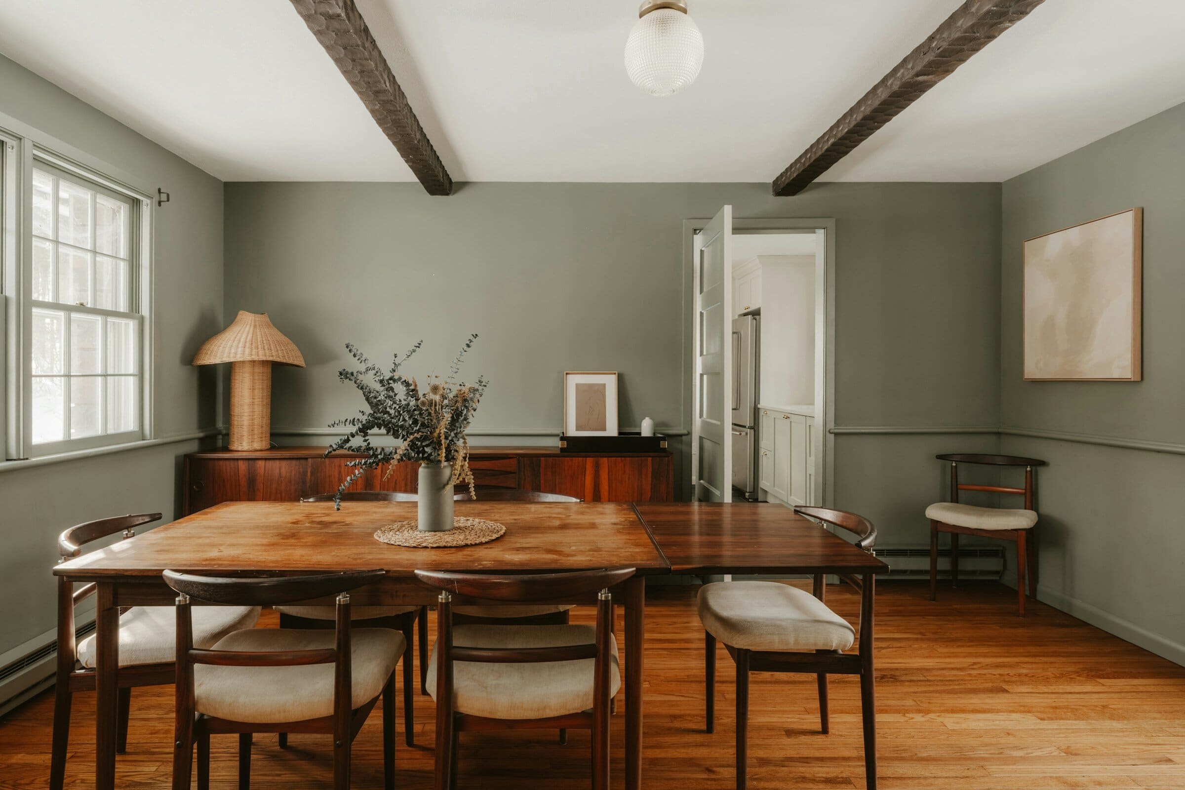 Salle à manger aux murs vert sauge et plafond blanc